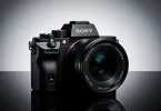 Sony Alpha a7 III mirrorless camera displayed on a dark gradient background with dramatic studio lighting, highlighting its 24MP full-frame sensor and premium design.